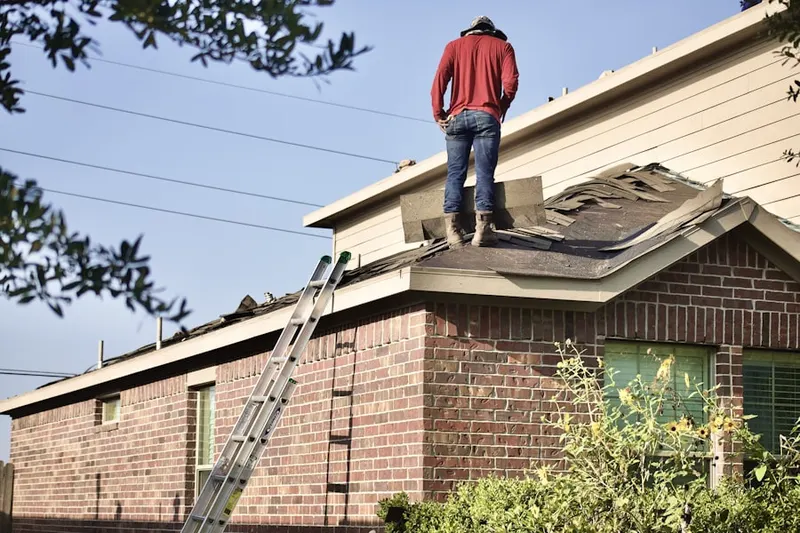 Professional roofer working on a residential roof in Selassie Villa